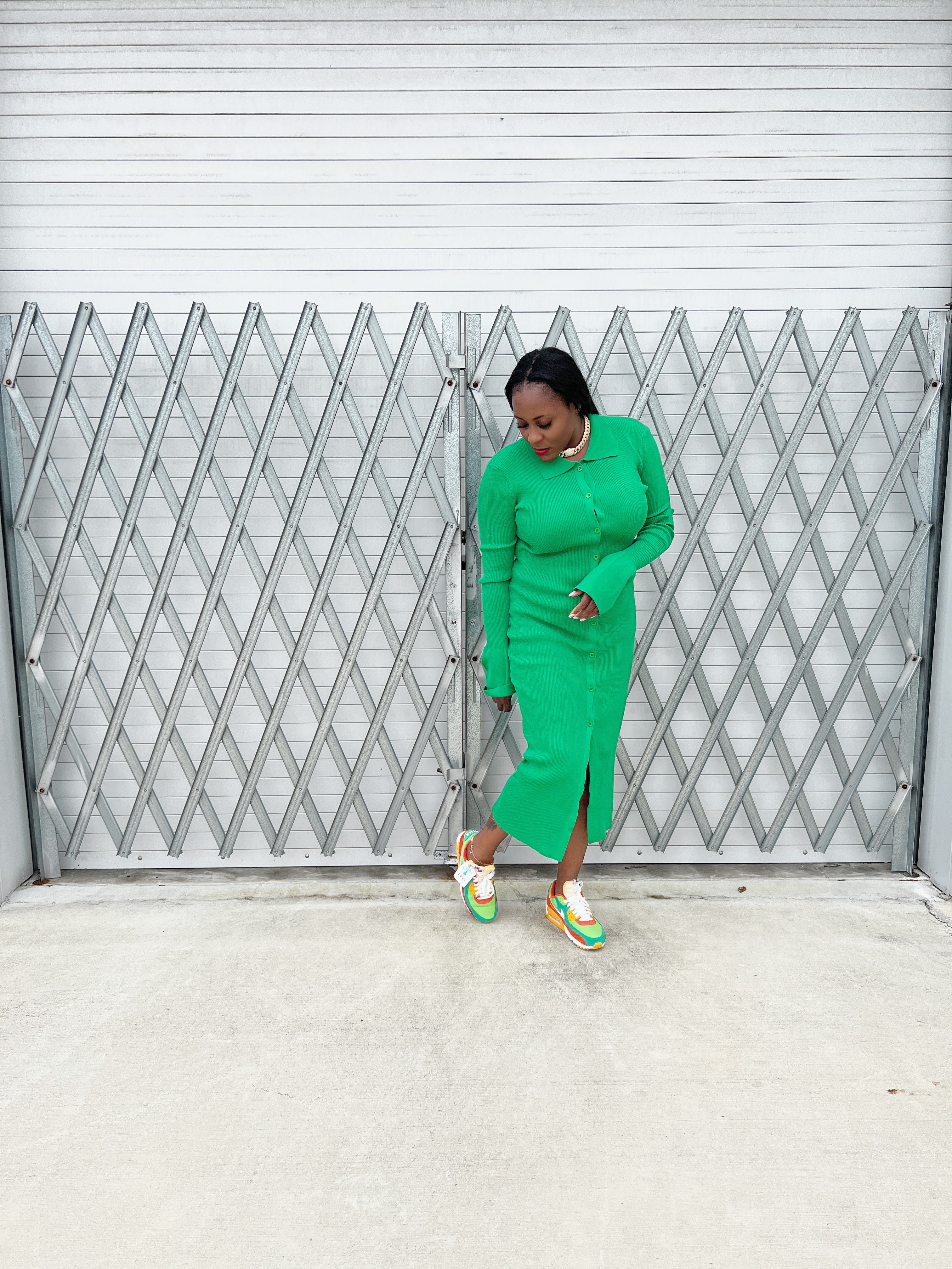 green ribbed maxi dress with a tailored fit, long sleeves, and flowing bell cuffs.”