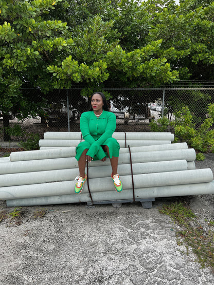Back view of a green ribbed maxi dress with a tailored fit, long sleeves, and flowing bell cuffs